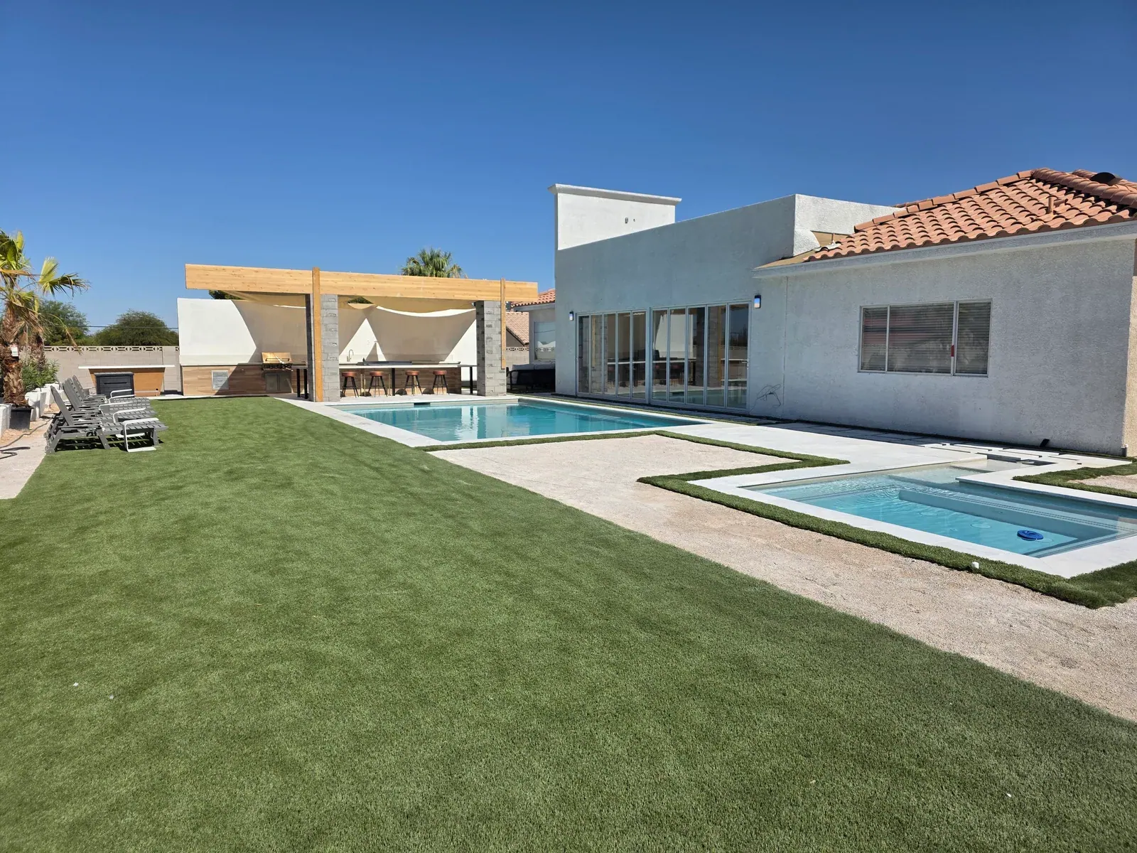 A private Las Vegas villa backyard with heated pool, spa and shaded outdoor kitchen
