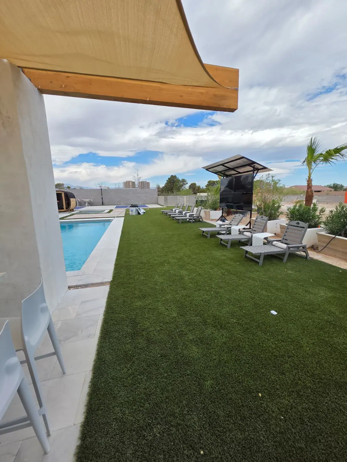 The lawn between the pool and the outdoor theater, lined with loungers