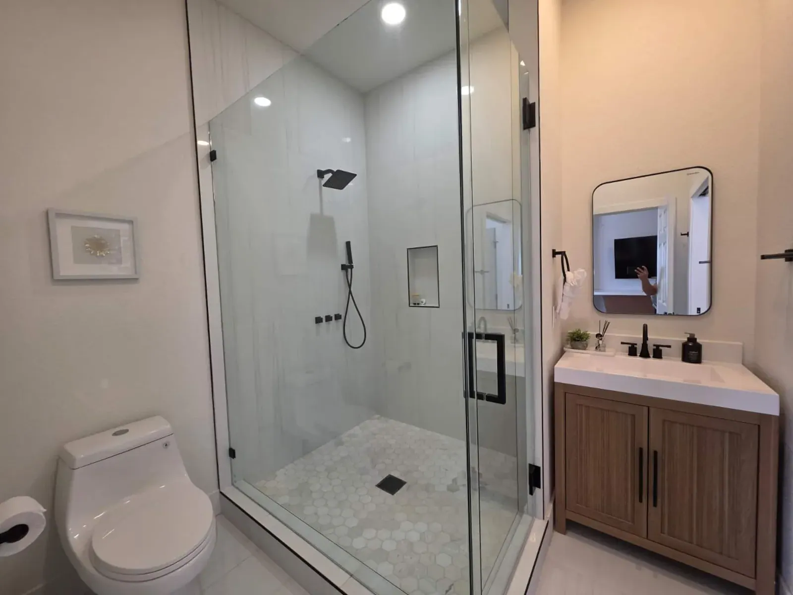 Full bathroom with a corner glass shower and oak vanity