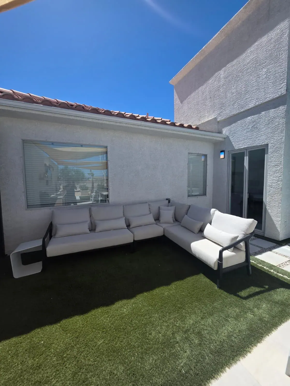 A corner sectional on the courtyard lawn, tucked against the villa wall