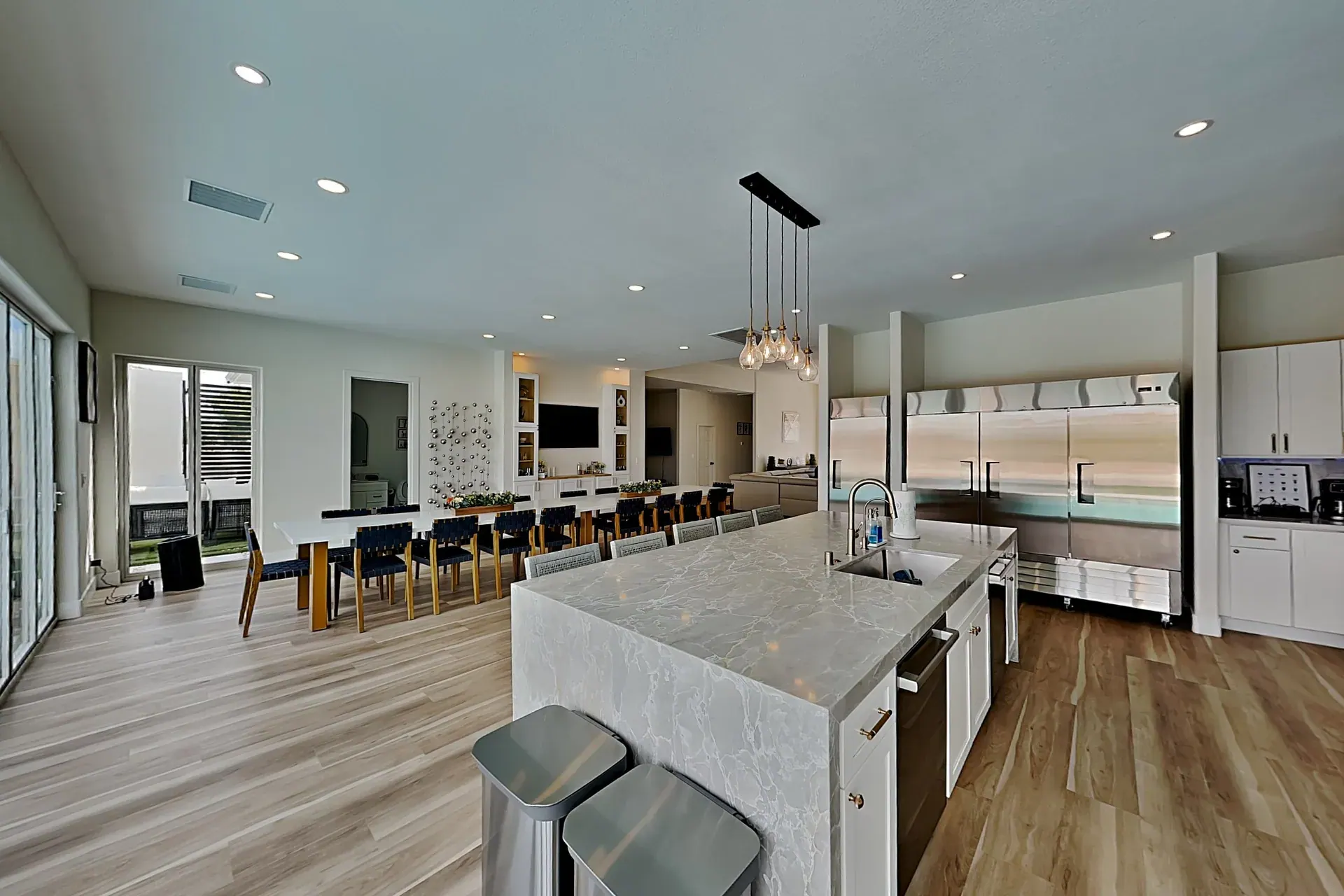 The chef’s kitchen island, commercial refrigerators and the dining table seating twenty