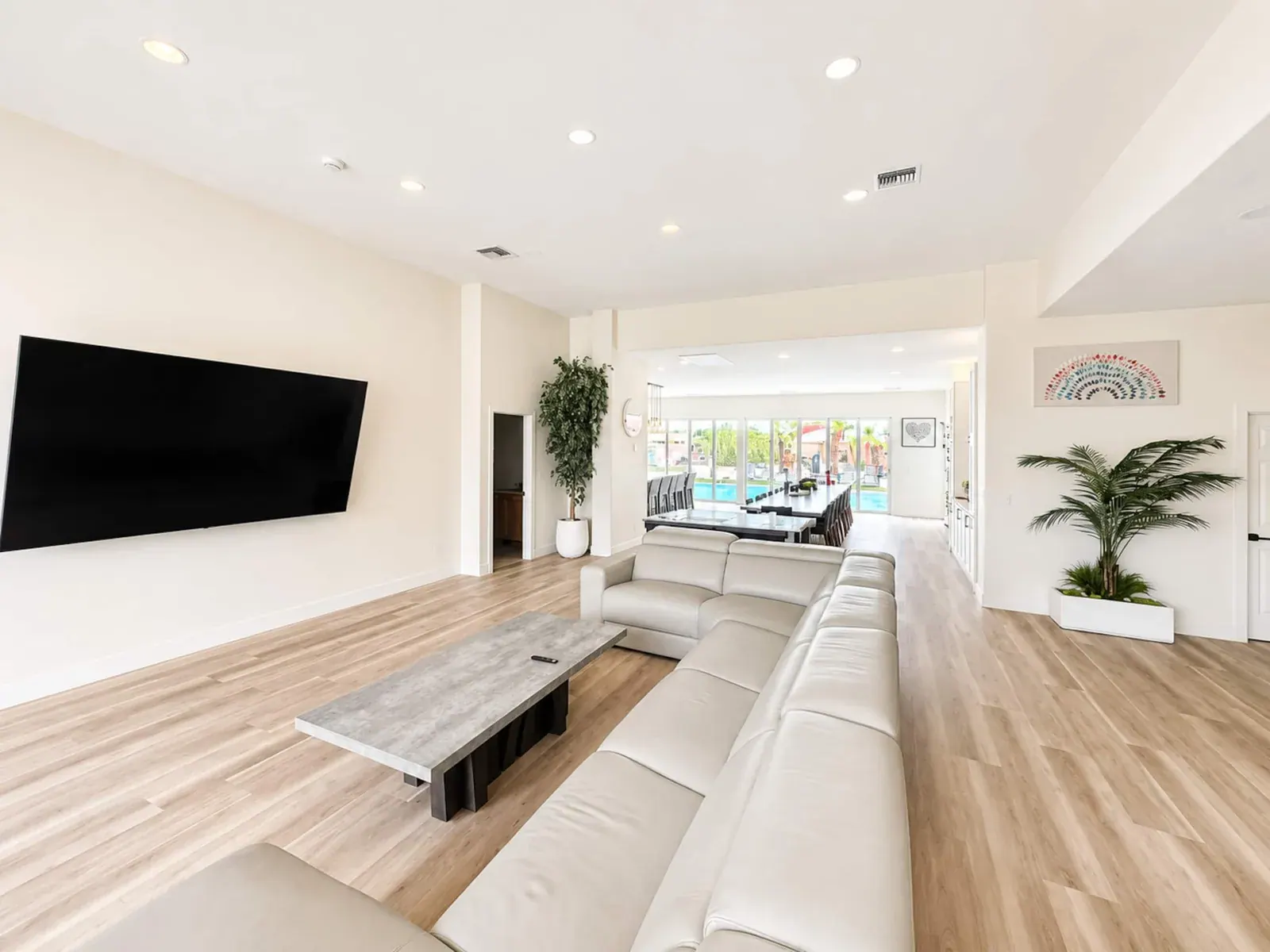 Open-concept living room with a wall of glass to the pool