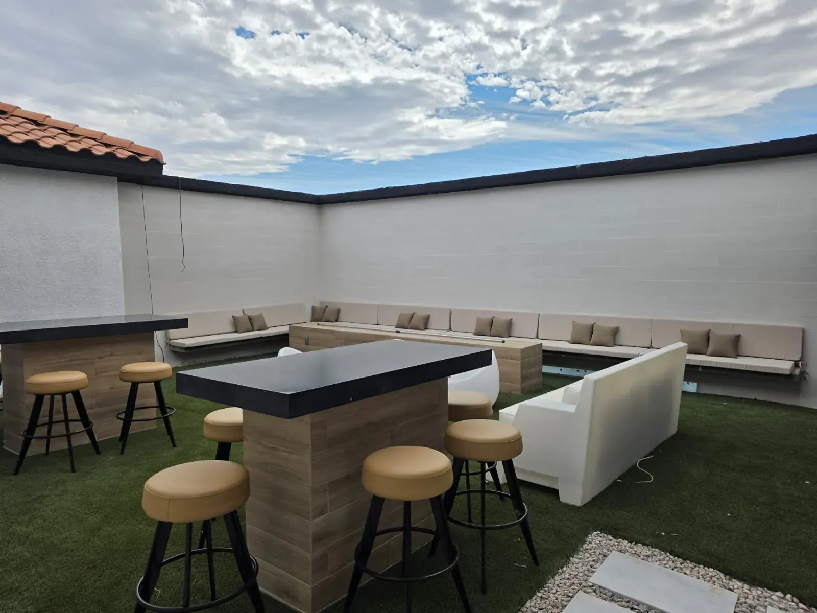 The walled lounge terrace — high-top bar tables, stools and built-in bench seating