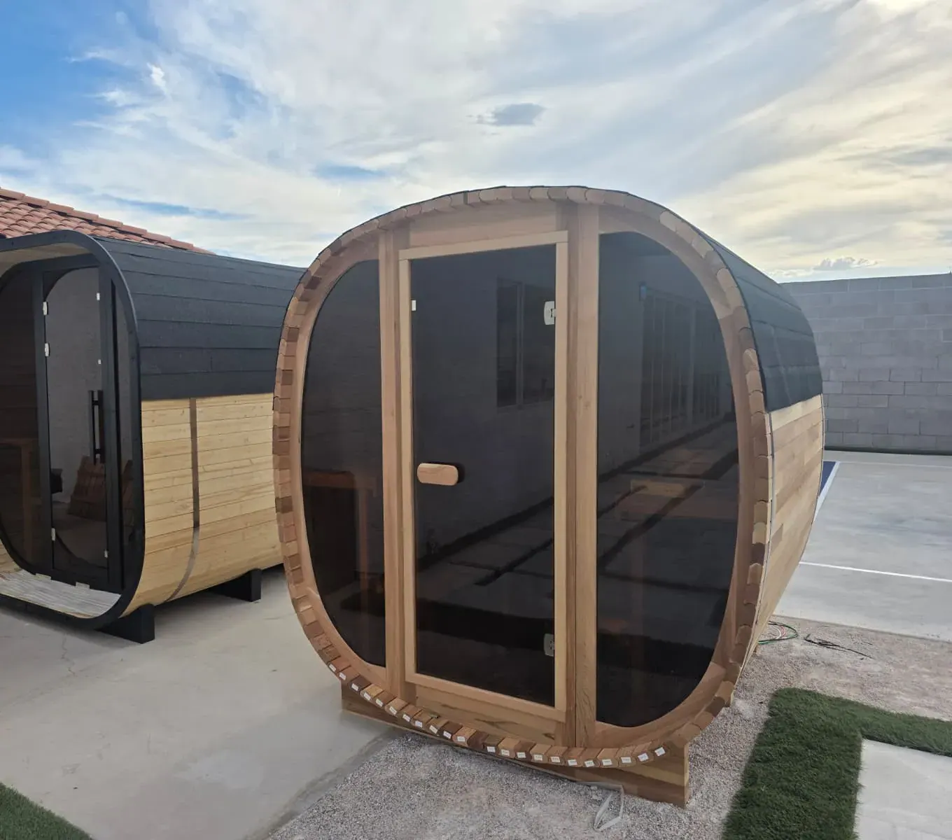 The pair of barrel-style outdoor cedar dry saunas, seating 12 between them