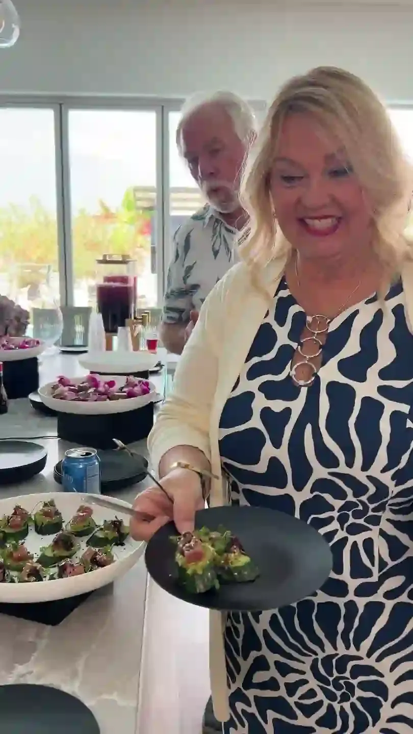 A guest serving the passed appetizers from a platter beside the dining table