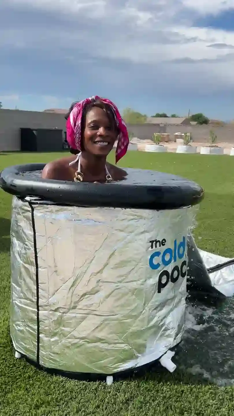 A guest sitting in one of the cold plunges out on the lawn