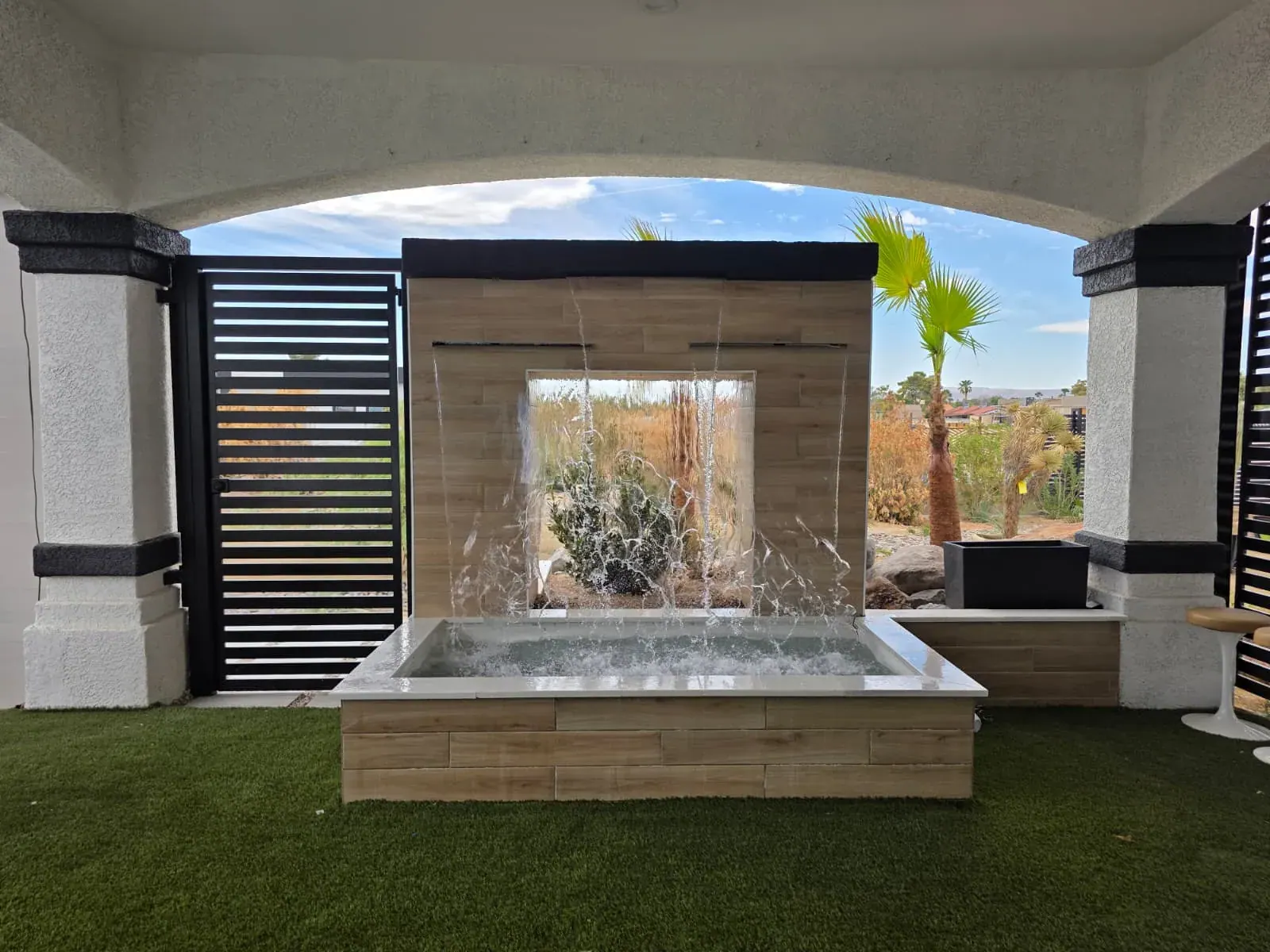 The waterfall plunge pool — twin sheets of water falling past a picture window into the churning basin
